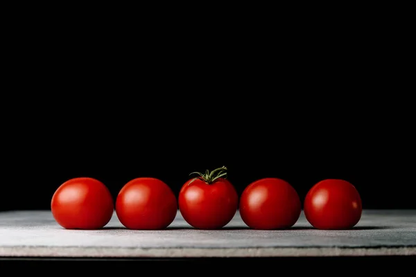 Koyu arkaplanda kırmızı domates çizgisi. Organik sağlıklı yiyecekler. Çiğ domates. Taze sebze.