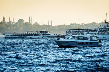 İstanbul 'un karanlık manzarası, Boğaz' daki bir teknenin camileri ve minareleri.