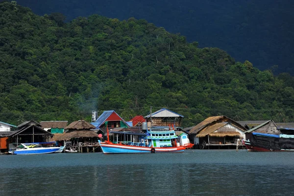 Tayland ve Chang adalarının arka planında tekneleri olan balıkçı köyü.