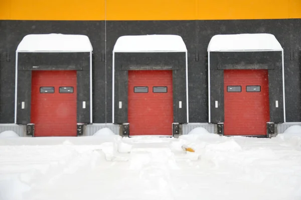 The empty loading bay of a large warehouse is covered with snow in winter. Unfavorable weather conditions