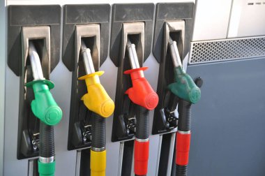 Benzin istasyonunda benzin bidonu. Farklı yakıt türleri için silah dağıtan hortumlar..