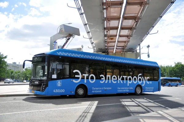 Moskova, Rusya - 30 Mayıs 2021: Şarj sırasında şarj istasyonunda elektrikli otobüs. Geleceğin çevre dostu şehir toplu taşımacılığı.