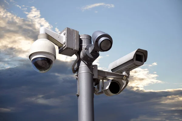 Many CCTV cameras on the background of the sky at sunset