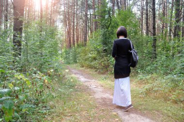 Güzel genç bir kadın yaz ormanında yürüyüşe çıkmış..