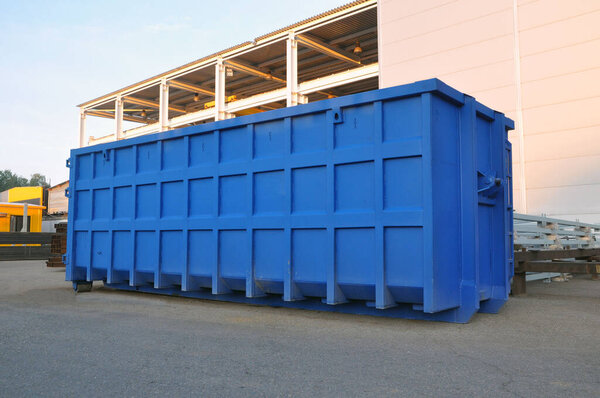 A container for collecting scrap metal for recycling on the territory of a production plant. Blue container.