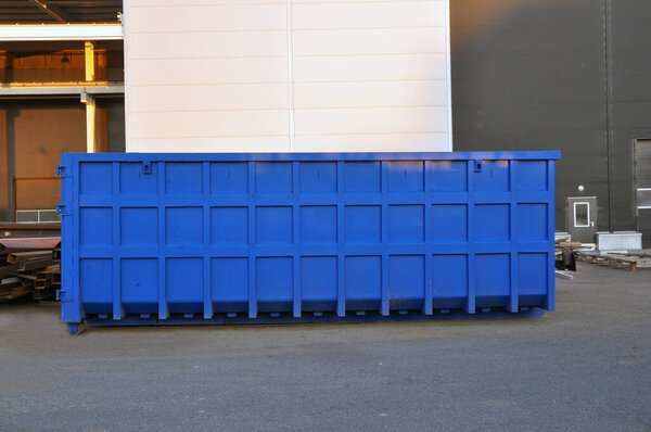 A container for collecting scrap metal for recycling on the territory of a production plant. Blue container.