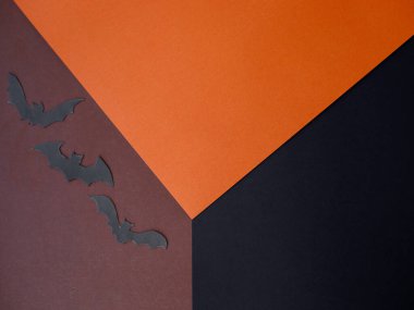 Turuncu, kahverengi ve siyah kağıttan oluşan yaratıcı küp düzeni. Ürün, promosyon, satış, afiş, sunum, kozmetik için konsept sahne gösterisi. Yarasa siluetleriyle Cadılar Bayramı konsepti