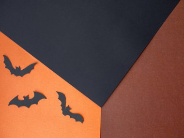 Turuncu, kahverengi ve siyah kağıttan oluşan yaratıcı küp düzeni. Ürün, promosyon, satış, afiş, sunum, kozmetik için konsept sahne gösterisi. Yarasa siluetleriyle Cadılar Bayramı konsepti