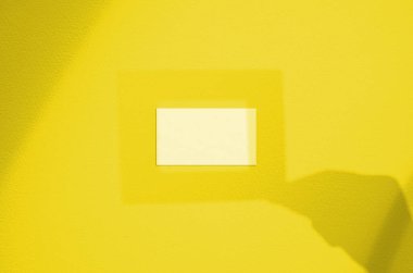 El gölgesinde çerçeveli boş beyaz kartvizit. Modern ve şık marka kart maketi. Pantone 'un 2021 Yılının Aydınlatıcı Rengi.