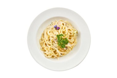 Beyaz tabakta peynirli, maydanozlu ve mantarlı kremalı spagetti carbonara. Beyaz arka planda izole edilmiş İtalyan makarna tabağı. Restoran menüleri, kafeler ve yemek tasarımı projeleri için mükemmel..