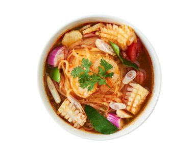 Beyaz kasede karides, kalamar, limon otu, limon yaprağı ve kırmızı biberli Tayland baharatlı şehriye çorbası. Lezzetli Tayland deniz mahsulleri eriştesi. Beyaz arka planda, kırpma yolu ile izole edilmiş. Menü ve yemek reklamları için mükemmel..