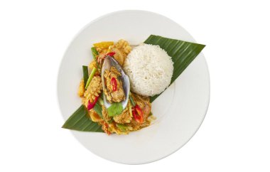 Tayland usulü kızarmış deniz ürünleri ve muz yaprağında pilav ile servis edilen köri tozu. Beyaz arka planda, kırpma yolu ile izole edilmiş lezzetli Tayland mutfağı. Restoran menüsü, yemek tasarımı ya da Asya baharatlı yemek konsepti için mükemmel..