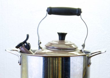 Bir tencerenin içindeki su ısıtıcısı ocağın tepesinde izole edilmiş yatay formatta fotokopi alanı ile kavramsal görüntü