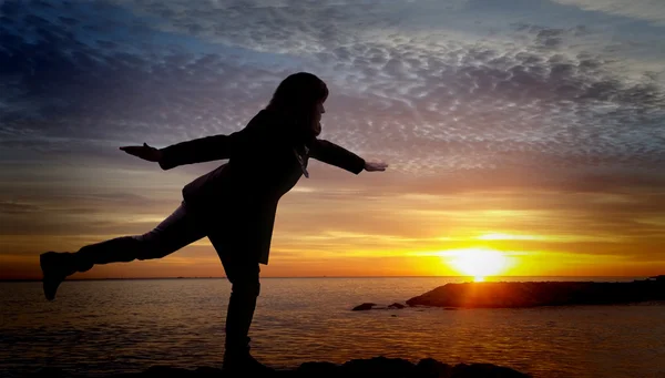 Girl in balance position and sunset — Stock Photo, Image
