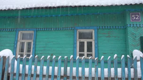 Traditional wooden house at hard snowfall. — Stock Video