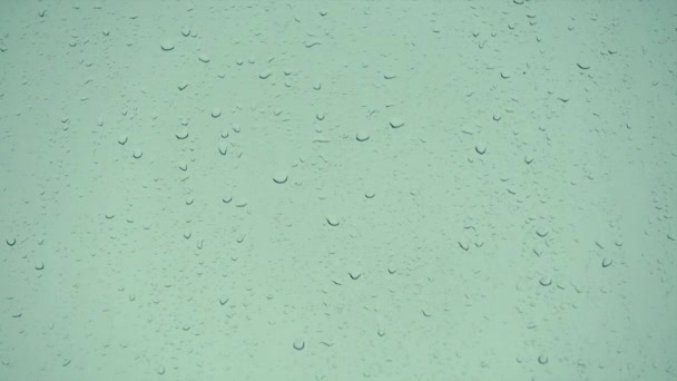 Des gouttes de pluie glissent sur une fenêtre contre le ciel couvert. — Video