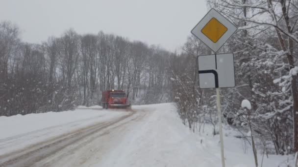 Smolensk, Ryssland - 25 december 2020: Vägen i snöfall. Snöröjningsmaskin. — Stockvideo