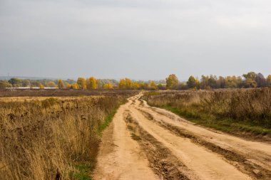 Kırsal toprak yol mesafeye doğru gidiyor. Kötü yolu olan kırsal alan