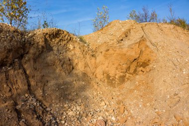 Kum ve çakıl çukuruna dökülen çöplerin manzarası. Yapı malzemelerinin çıkarılması