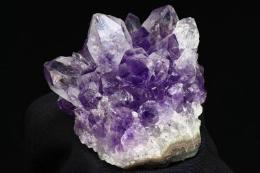 Karanlık bir arka planda parlak, güzel bir ametist druse. Leylak kristalleri kümesi