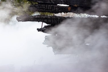 Yangından sonra kömürleşmiş ahşap duvarlar. Yanmış bir binada yanmış tahtalar. Kasvetli küllerle dolu bir arkaplan