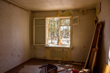 Terk edilmiş bir evin penceresi kırılmış, pilleri kesilmiş.