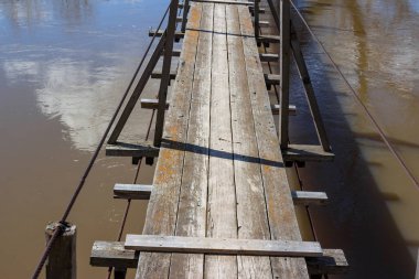 Nehrin üzerinde tahta güvertelerle asılı duran yaya köprüsü.