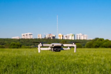 DJI Mini 2 arka planda tarlaları ve evleri olan uçuşta İHA: Rusya - Haziran 2021