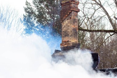 Küllerin üstünde duman, tahta bir binada çıkan yangından sonra duman içinde baca.