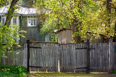 20. yüzyılın başlarında ahşap bir evin arka planına bakan eski ahşap bir çitin manzarası.