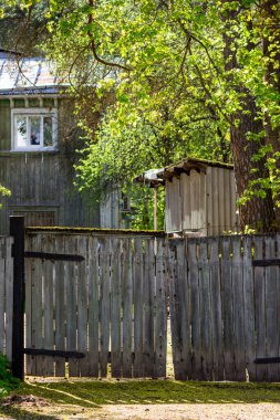 20. yüzyılın başlarında ahşap bir evin arka planına bakan eski ahşap bir çitin manzarası.