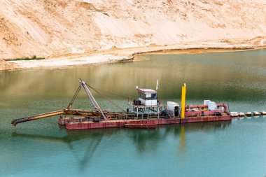 Dredger, taşan bir kum madeninde yükseltilmiş toprak emme cihazı ile birlikte.