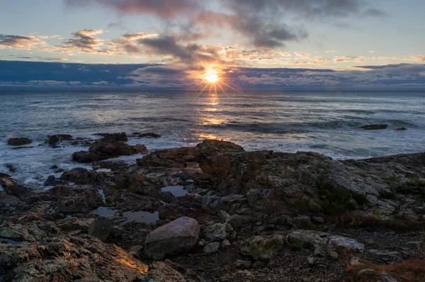 Lever de soleil sur une côte rocheuse — Photo