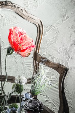 Kırmızı çiçek, sandalye ve duvar