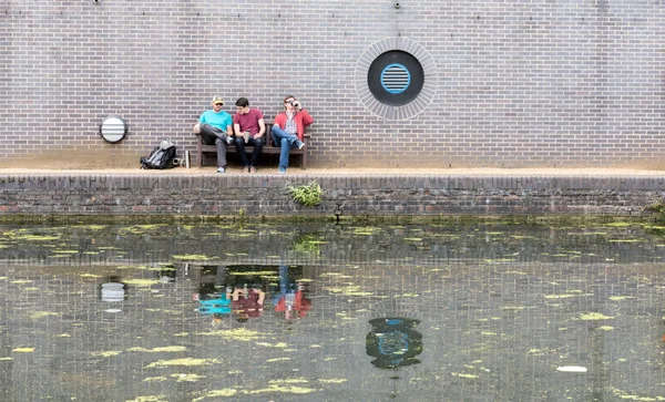 Três caras conversando perto do canal — Fotografia de Stock