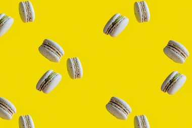 Fransız tatlılığı. Sarı arkaplanda havadaki makarunlar izole edilmiş.. 