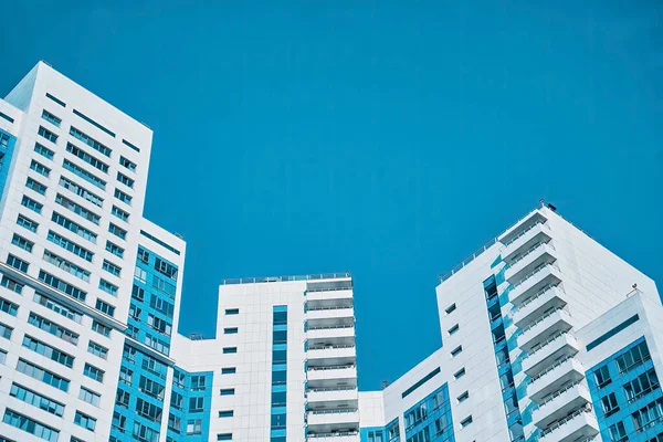 파란색 하늘을 배경으로 파란색 창문 이 있는 아파트 단지 — 스톡 사진