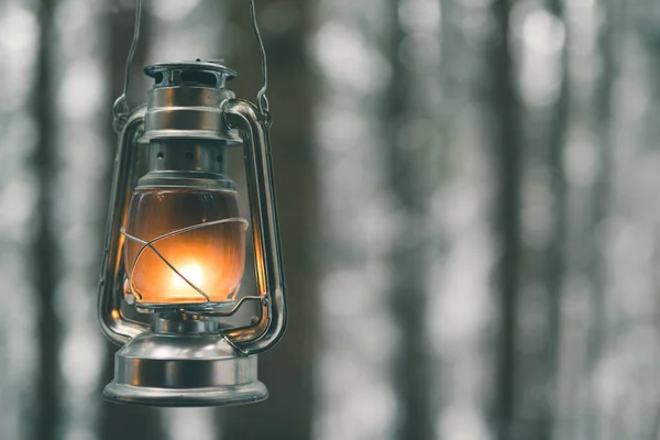 Lampa naftowa ze światłem na rozmytym tle lasu zimowego Obraz Stockowy