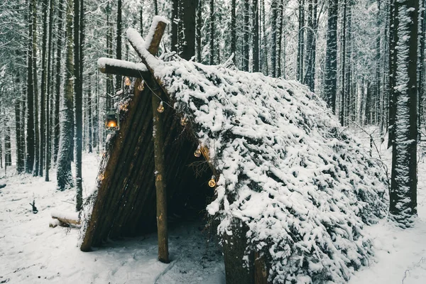 Prymitywny bushcraft schronienie przetrwanie z Christmas girlandy żarówki w lesie zimowym Obrazek Stockowy