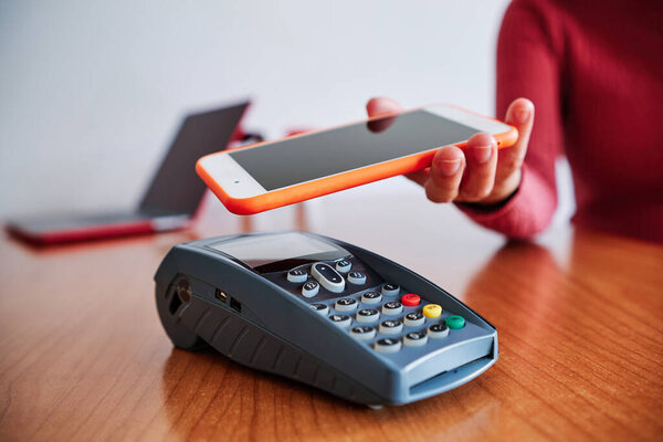 женщина рука с помощью мобильного телефона, чтобы платить бесконтактные