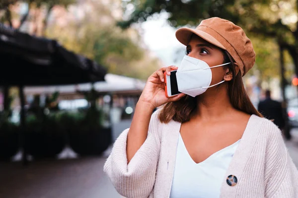 Femme noire avec masque de protection à l'aide d'un smartphone - nouveau normal — Photo