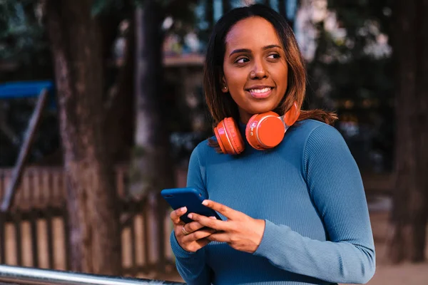 Mujer negra usando auriculares al aire libre —  Fotos de Stock