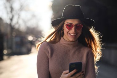 Dışarıda cep telefonunu kullanan genç bir kadın..