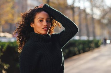 Sokakta poz veren kendine güvenen bir kadın..