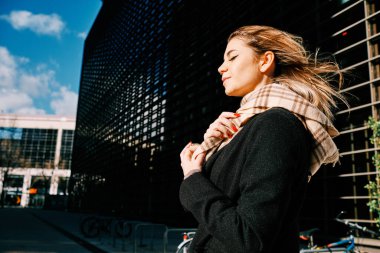 Dışarıda dikilen bir kadının yan görüntüsü.