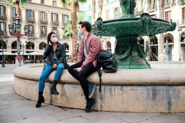 Arkadaşlar dışarıda maske takıp konuşuyorlar..