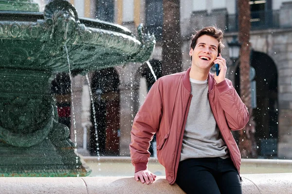 Young man talking on the phone outdoors.