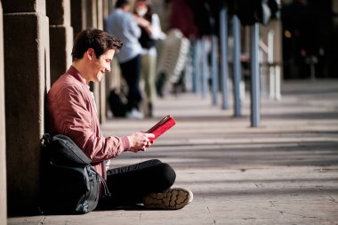Genç adam dışarıda dijital tablet kullanıyor..
