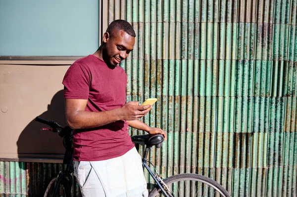 Joven afroamericano hombre con bicicleta y teléfono inteligente —  Fotos de Stock