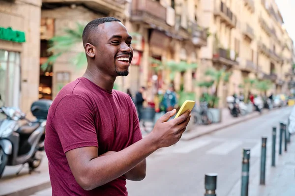 Joven usando un smartphone al aire libre en medio de la calle —  Fotos de Stock